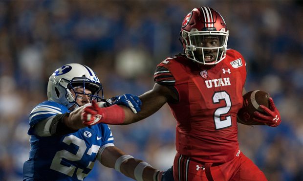Zach Moss #2 of the Utah Utes fends off Zayne Anderson #23 of the BYU Cougars during their game at ...