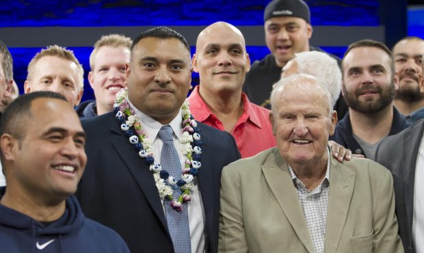 Former players and former head coach LaVell Edwards pose for photos with new head coach Kalani Sita...