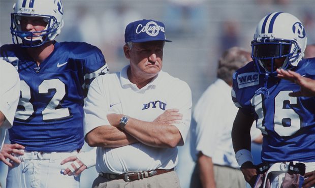 Head coach Lavell Edwards of Brigham Young University stands between his players Ronney Jenkins and...