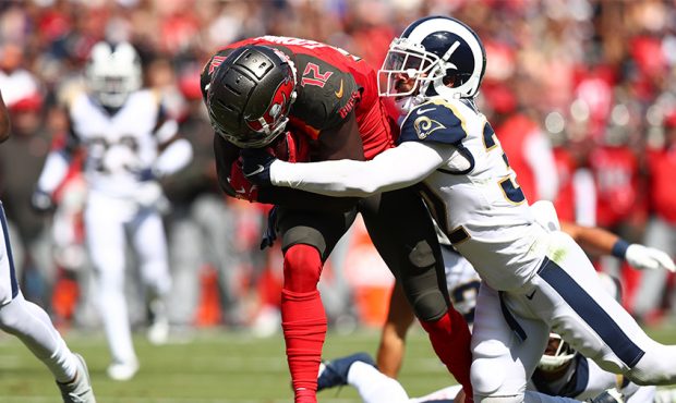 Chris Godwin #12 of the Tampa Bay Buccaneers is tackled by Eric Weddle #32 of the Los Angeles Rams ...