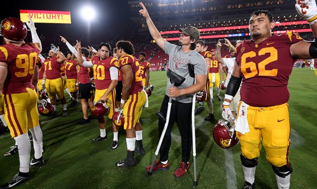 JT Daniels #18 of the USC Trojans in crutches, celebrates a 31-23 win over Fresno State Bulldogs at...