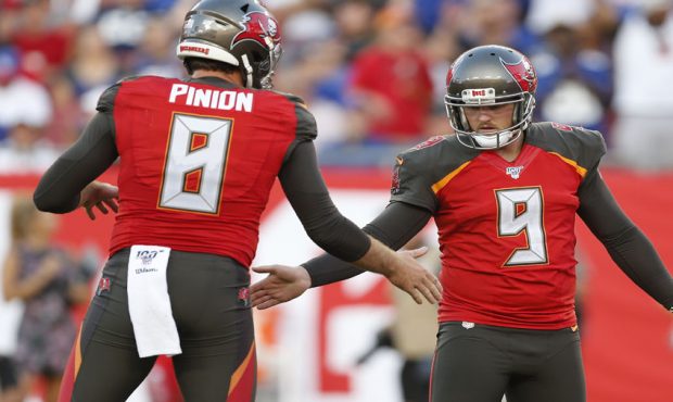 Kicker Matt Gay #9 and holder Bradley Pinion #8 of the Tampa Bay Buccaneers shake hands after a suc...
