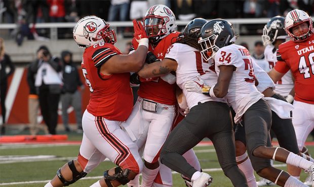 Zack Moss #2 of the Utah Utes is pushed over the goal line for a first half touchdown against the W...