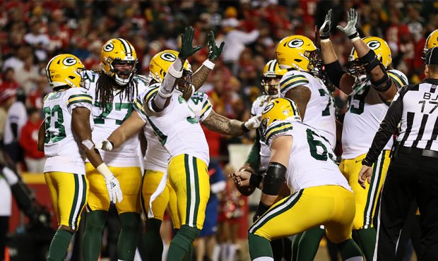 Jamaal Williams #30 of the Green Bay Packers celebrates with teammates after a one-yard rushing tou...