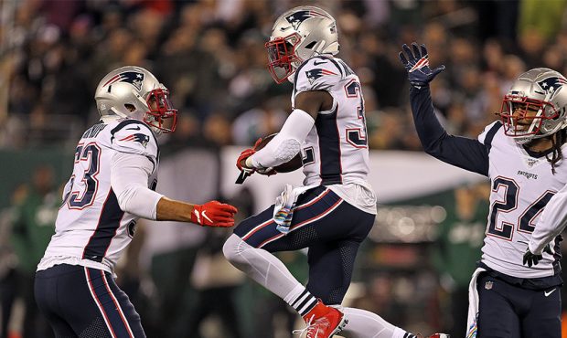 Devin McCourty #32 of the New England Patriots jumps up and celebrates his interception with Kyle V...
