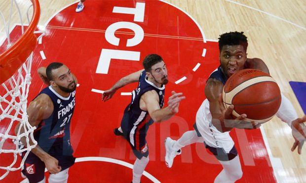 Donovan Mitchell of the USA shoots against Nando De Colo and Rudy Gobert of France during the quart...
