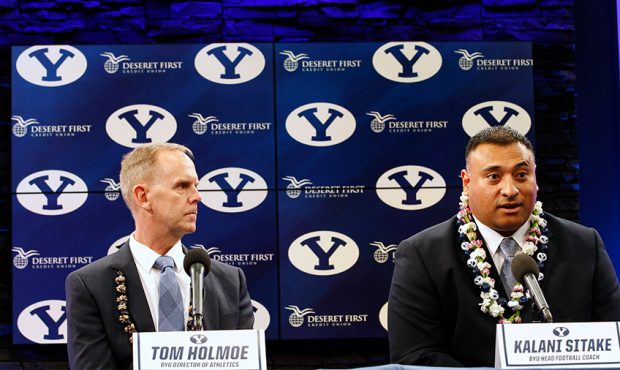Brigham Young University Athletic Director Tom Holme, (L) listens to BYU's new head football coach,...