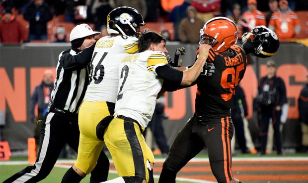 Quarterback Mason Rudolph #2 of the Pittsburgh Steelers fights with defensive end Myles Garrett #95...