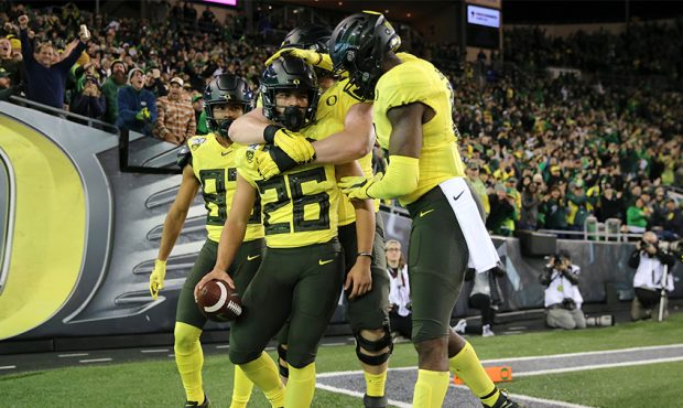Travis Dye #26 of the Oregon Ducks celebrates with teammates after running for a 33-yard touchdown ...