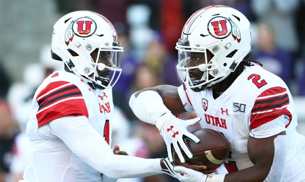 Tyler Huntley #1 hands the ball off to Zack Moss #2 of the Utah Utes against the Washington Huskies...