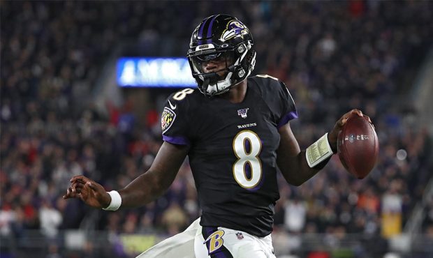 Quarterback Lamar Jackson #8 of the Baltimore Ravens scores a first quarter touchdown against the N...