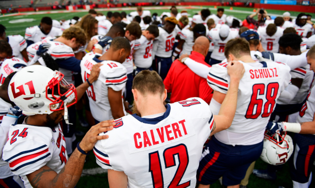 PISCATAWAY, NJ - OCTOBER 26: Stephen Calvert #12 of the Liberty Flames prays with his team after th...
