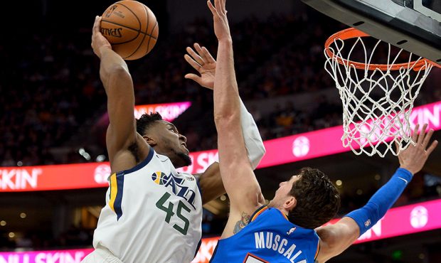 Donovan Mitchell #45 of the Utah Jazz attempts a dunk over Mike Muscala #33 of the Oklahoma City Th...