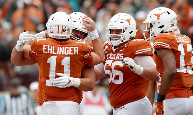 Sam Ehlinger #11 of the Texas Longhorns is congratulated after a touchdown by Zach Shackelford #56 ...