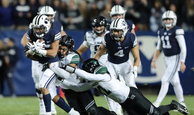 Brigham Young Cougars wide receiver Aleva Hifo (15) drags two would be tacklers Hawaii Warriors lin...