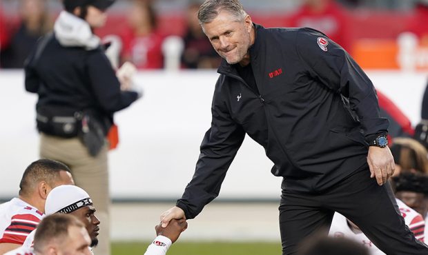 Head coach Kyle Whittingham of the Utah Utes shakes the hand of a player while his team warms up pr...