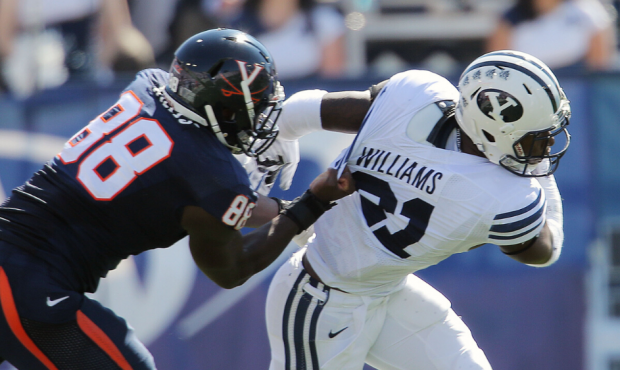 Brigham Young running back Jamaal Williams (21) is tackled by Virginia linebacker Max Valles (88) S...