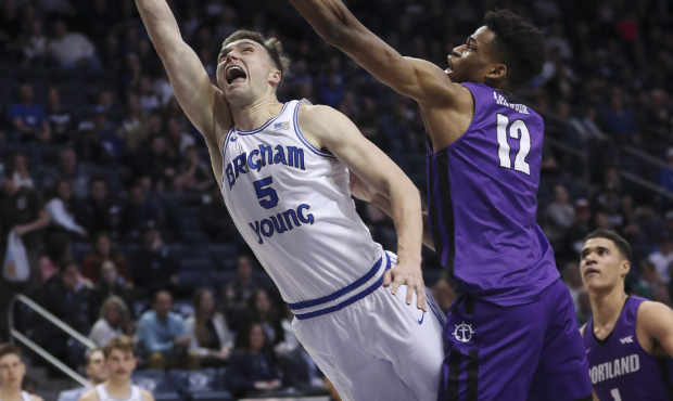 BYU Cougars guard Jake Toolson (5) drives by Portland Pilots center Theo Akwuba (12) in Provo on Sa...