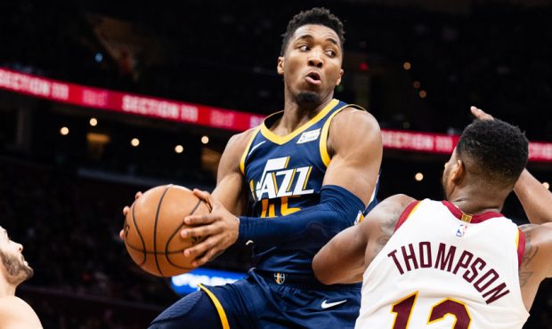 Donovan Mitchell #45 of the Utah Jazz passes around Tristan Thompson #13 of the Cleveland Cavaliers...