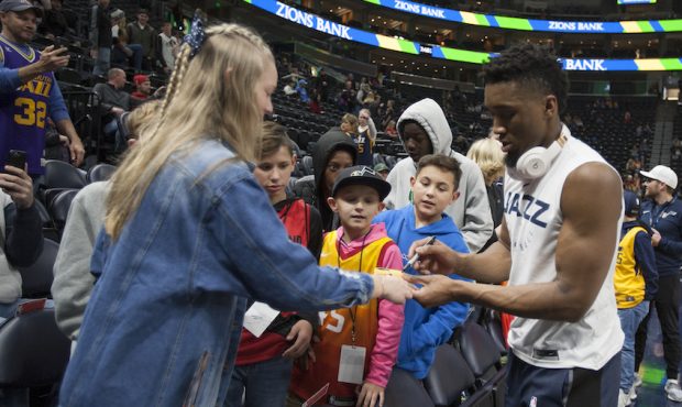 Donovan Mitchell #45 of the Utah Jazz signs autographs for fans during warmups (Photo by Chris Gard...