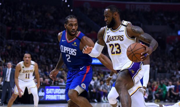 LeBron James #23 of the Los Angeles Lakers drives to the basket on Kawhi Leonard #2 of the LA Clipp...
