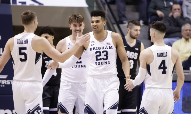 BYU forward Yoeli Childs celebrates with Jake Toolson and Alex Barcello during BYU's win over No. 2...