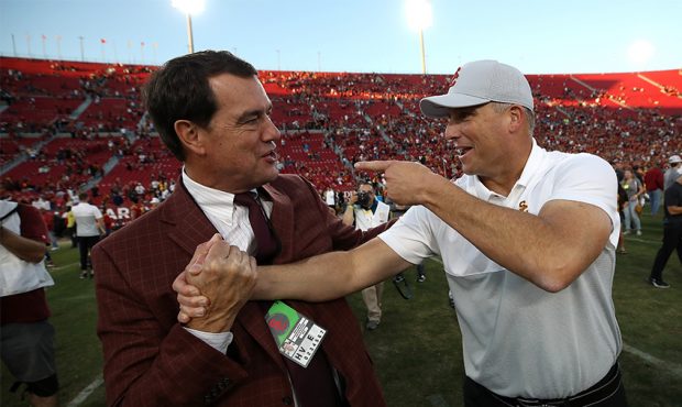 (L-R) Athletic Director Mike Bohn of the USC Trojans shakes hands with head coach Clay Helton of th...