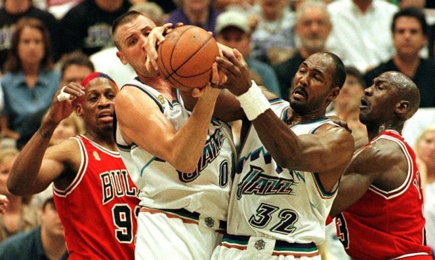 Karl Malone fights for ball against bulls...