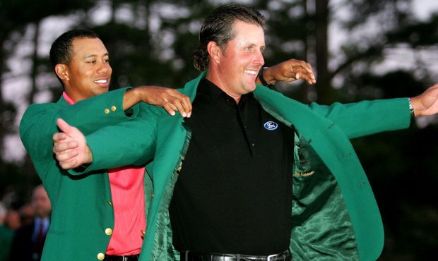 Tiger Woods puts the green jacket on Phil Mickelson after he won The Masters at the Augusta Nationa...