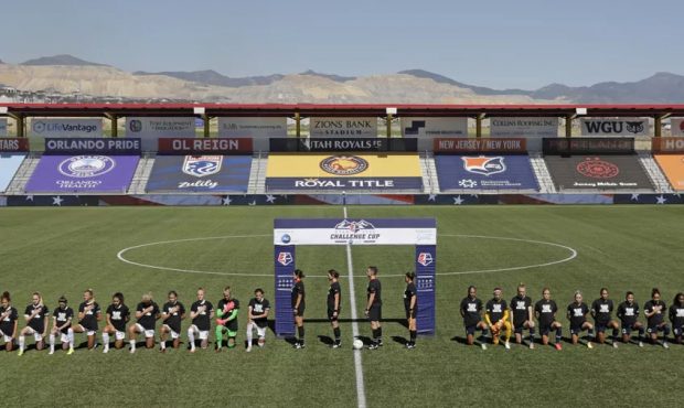 Players for the Portland Thorns, left, and the North Carolina Courage kneel during the national ant...