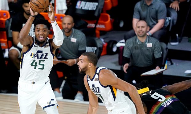 Donovan Mitchell #45 of the Utah Jazz passes the ball as teammate Rudy Gobert, and moves up court a...
