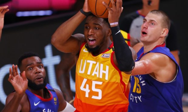 Utah Jazz guard Donovan Mitchell jumps past the Denver Nuggets Paul Millsap and Nikola Jokic. (Phot...