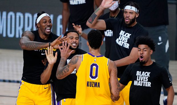 Kyle Kuzma #0 of the Los Angeles Lakers is congratulated by teammates after hitting the game-winnin...