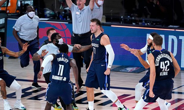 Luka Doncic #77 of the Dallas Mavericks celebrates with teammates after making a game-winning 3-poi...