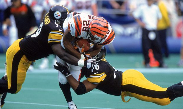 Kevin Henry #76 and Levon Kirkland #99 of the Pittsburgh Steelers take down Corey Dillon #28 of the...