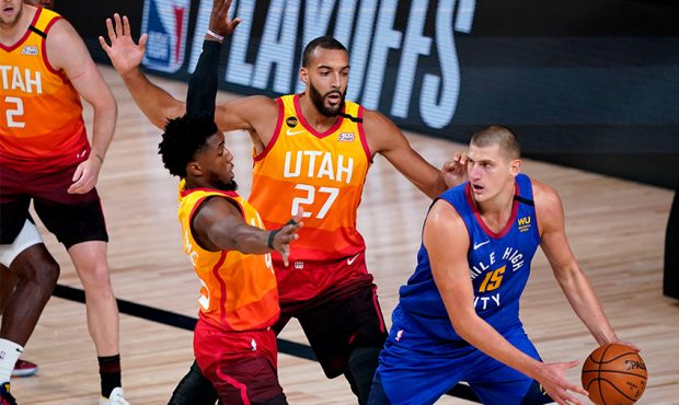 Denver Nuggets' Nikola Jokic #15 looks to pass under pressure from Utah Jazz's Rudy Gobert #27 and ...