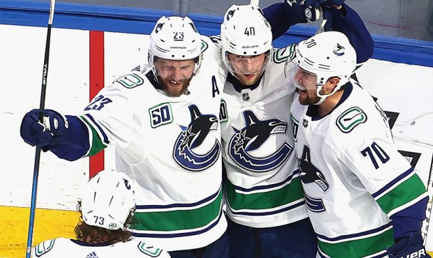 Alexander Edler #23, Elias Pettersson #40 and Tanner Pearson #70 of the Vancouver Canucks celebrate...