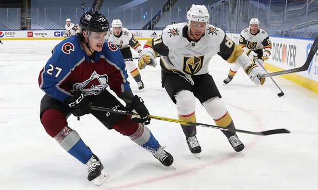 Avalanche and Knights player battle for puck...