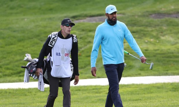 Tony Finau of the United States and caddie Mark Urbanek walk the tenth hole during the second round...