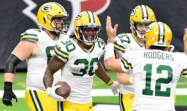 Jamaal Williams #30 of the Green Bay Packers celebrates with Aaron Rodgers #12 after rushing for a ...