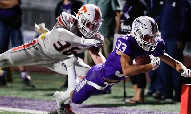 Lehi’s Carson Gonzalez carries the ball as he dives into the end zone for a touchdown during a hi...