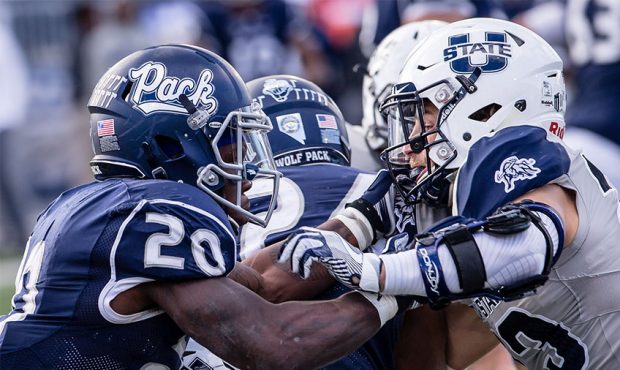 Running back James Butler #20 of the Nevada Wolf pack meets up with safety Gaje Ferguson #23 of the...