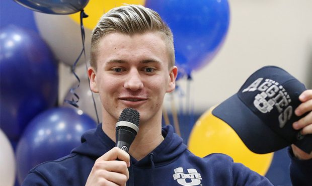 Cooper Legas holds up an Aggie hat as Orem High School athletes sign their letters of intent during...