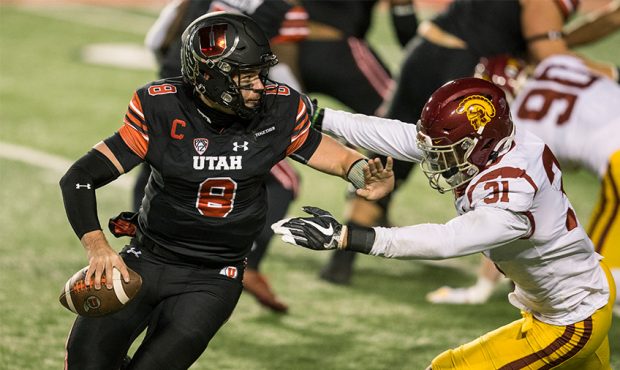 Jake Bentley #8 of the Utah Utes gets away from Hunter Echols #31 of the USC Trojans during their g...