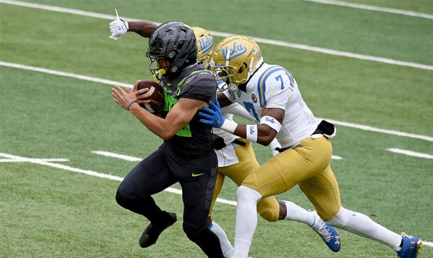 Travis Dye #26 of the Oregon Ducks runs the ball in for a touchdown as Mo Osling #7 of the UCLA Bru...