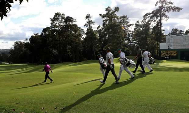 Paul Casey of England, Patrick Reed of the United States and Tony Finau of the United States walk o...