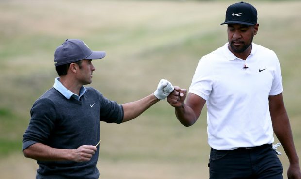 Retired soccer player Landon Donovan fist bumps Tony Finau of the United States after playing his s...
