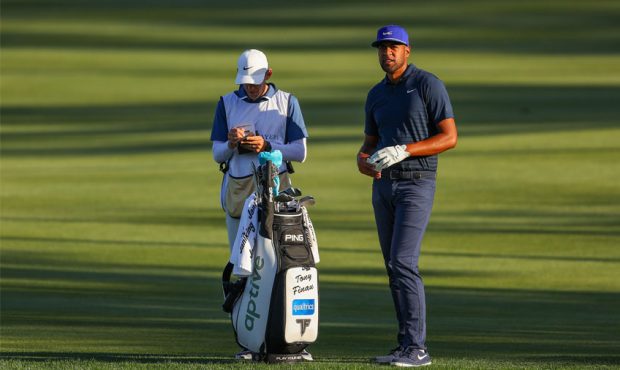 Tony Finau of the United States talks with his caddie on the ninth hole during the second round of ...