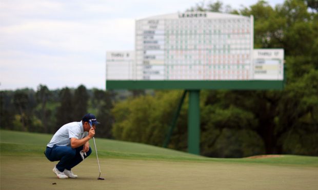 Justin Rose of England lines up a putt on the 18th green during the first round of the Masters at A...