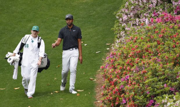 Tony Finau of the United States walks to the sixth green with his caddie, Mark Urbanek, during the ...